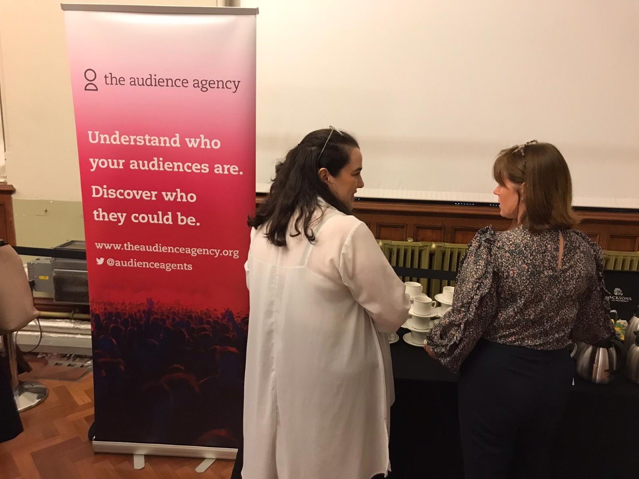 Attendees chatting by The Audience Agency stand at at Creu Cymra 2022